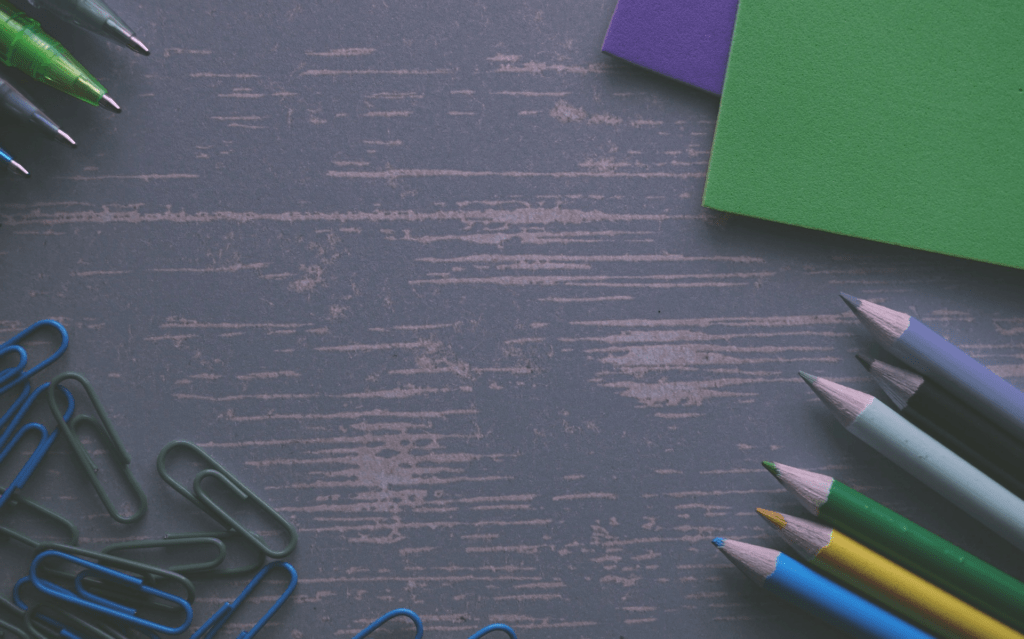 conseils-auteurs-stylos-crayons-trombones-fond-bois Conseils pour auteurs : stylos, crayons et trombones colorés sur fond bois, symbolisant les outils essentiels pour écrire et corriger un manuscrit.